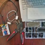 red and silver scissors beside white laptop computer