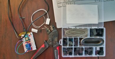 red and silver scissors beside white laptop computer